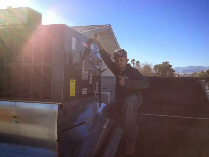 HVAC technician performing Heat Pump Repair on a rooftop unit in Bolivar